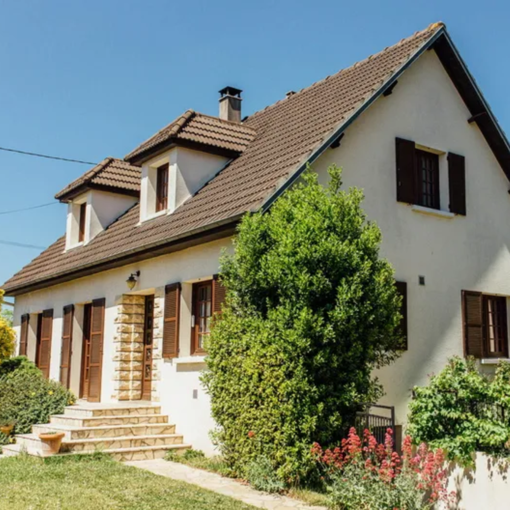 Grande maison avec un jardin fleuri.