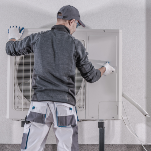 Un ouvrier qui installe une pompe à chaleur air-eau performante et écologique.